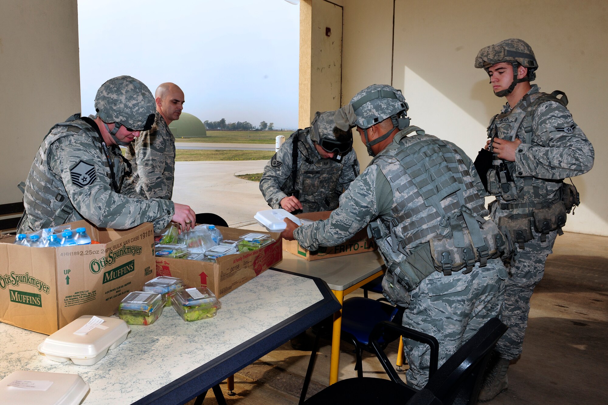Senior leadership from the 39th Security Forces Squadron delivers the first carry-out meals to defenders on post, Dec. 2, 2014, at Incirlik Air Base, Turkey. This delivery marked the start of a new program to offer hot meals to security forces Airmen who cannot make it to the dining facility due to mission requirements. (U.S. Air Force photo by Senior Airman Krystal Ardrey/Released)