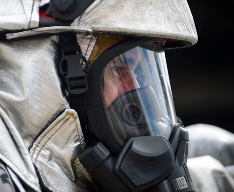 A firefighter from El Salvador approaches a simulated petroleum, oil, and lubricants running pool