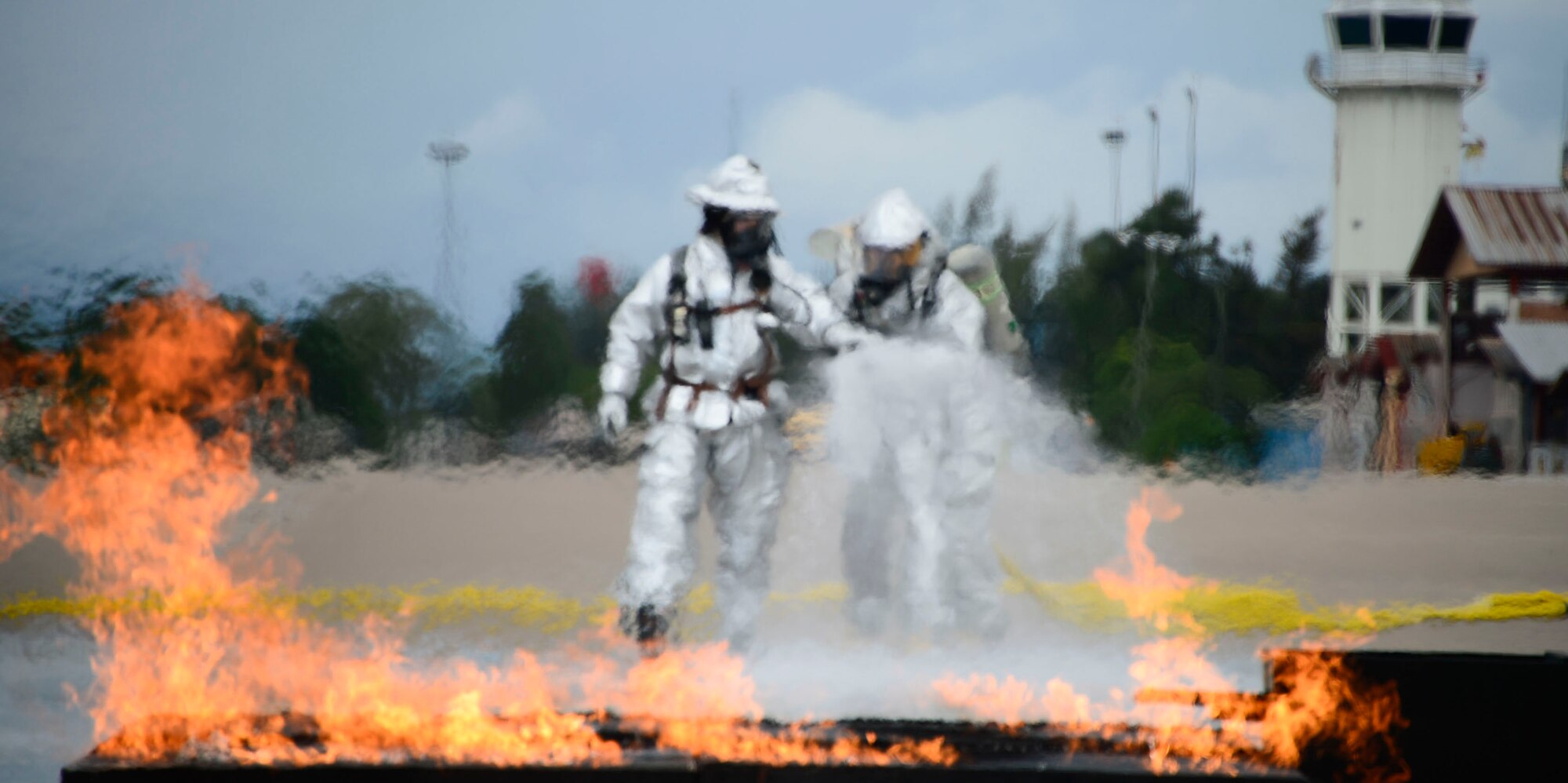Firefighters from El Salvador start to extinguish a simulated petroleum, oil, and lubricants running pool fire during the El Salvador’s Autonomous Executive Port Commission airport firefighter live-fires on Soto Cano Air Base, Honduras, Dec. 3, 2014.  The 612th ABS firefighters facilitated El Salvador’s Autonomous Executive Port Commission airport firefighter qualification by providing live-fires.  The Salvadoran airport firefighters have a requirement very similar to the United States standards that requires members of their airport fire departments to be qualified annually on their ability to control a live-fire.  (U.S. Air Force photo/Tech. Sgt. Heather Redman)