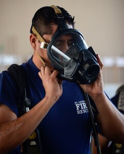 A firefighter from El Salvador tries on a breathing mask during the self-contained breathing apparatus orientation given by the 612th Air Base Squadron firefighters during El Salvador’s Autonomous Executive Port Commission airport firefighter live-fires on Soto Cano Air Base, Honduras, Dec. 3, 2014.  The 612th ABS firefighters facilitated El Salvador’s Executive Port Commission airport firefighter qualification by providing live-fires.  The Salvadoran airport firefighters have a requirement very similar to the United States standards that requires members of their airport fire departments to be qualified annually on their ability to control a live-fire.  (U.S. Air Force photo/Tech. Sgt. Heather Redman)