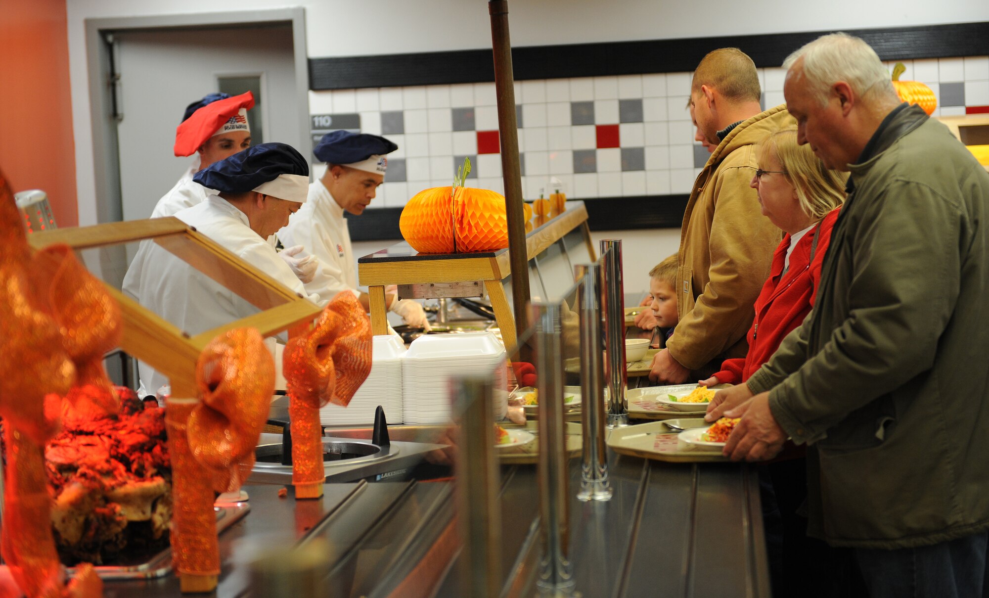 Retirees wait in line to be served a Thanksgiving meal at the Ozark Inn dining facility Nov. 28, 2014 at Whiteman Air Force Base, Mo.  The Thanksgiving meal served by senior leadership is an annual tradition at Whiteman to boost morale for those who cannot travel home for the holiday. (U.S. Air Force photo by Airman 1st Class Joel Pfiester/Released)
