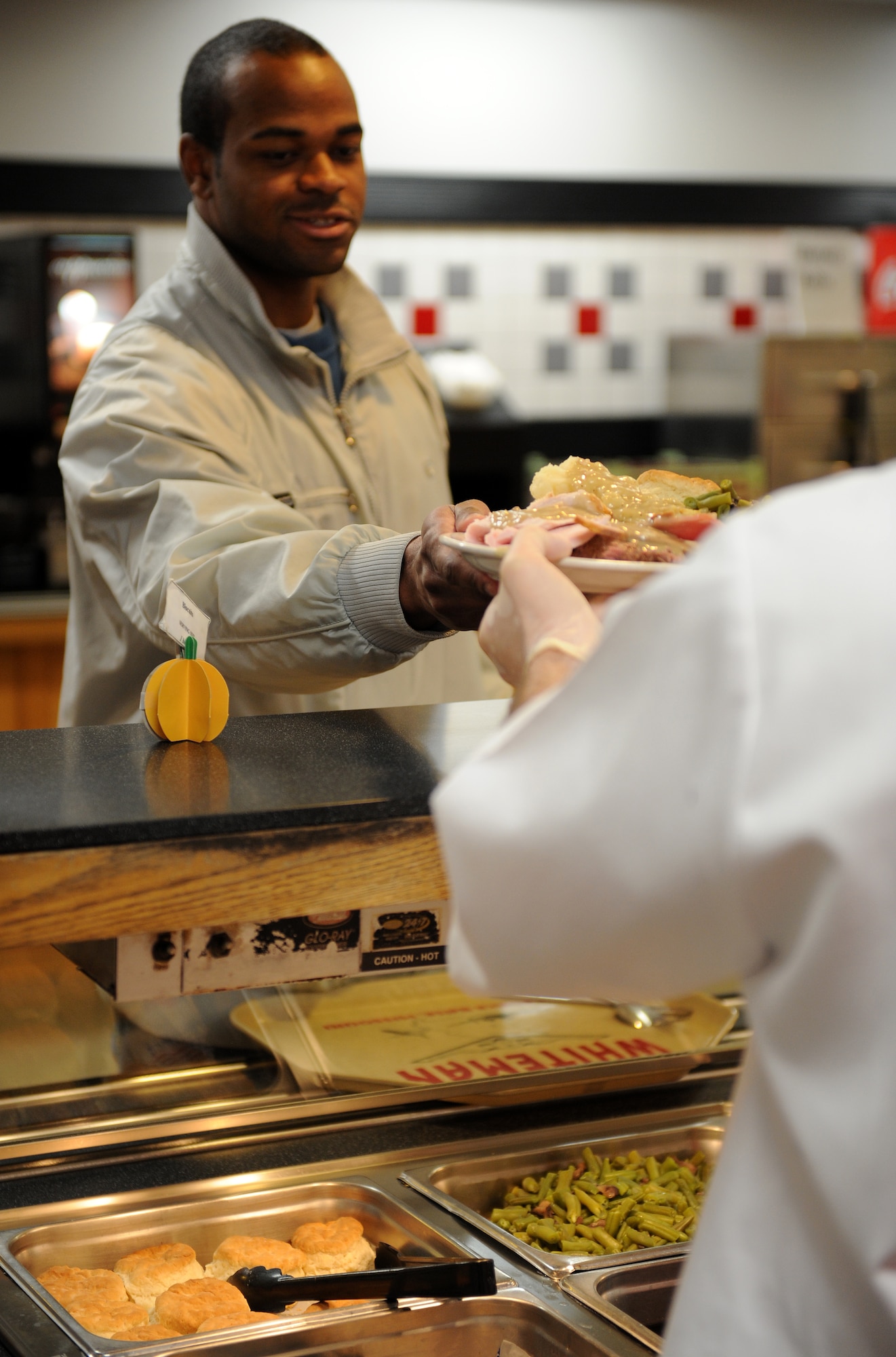 A member of Team Whiteman receives a Thanksgiving meal at the Ozark Inn dining facility on Whiteman Air Force Base, Mo., Nov. 28, 2014. The Thanksgiving meal is served to ensure that Airmen unable to travel home for the holidays are still able to receive a traditional Thanksgiving meal. (U.S. Air Force photo by Airman 1st Class Joel Pfiester/Released)
