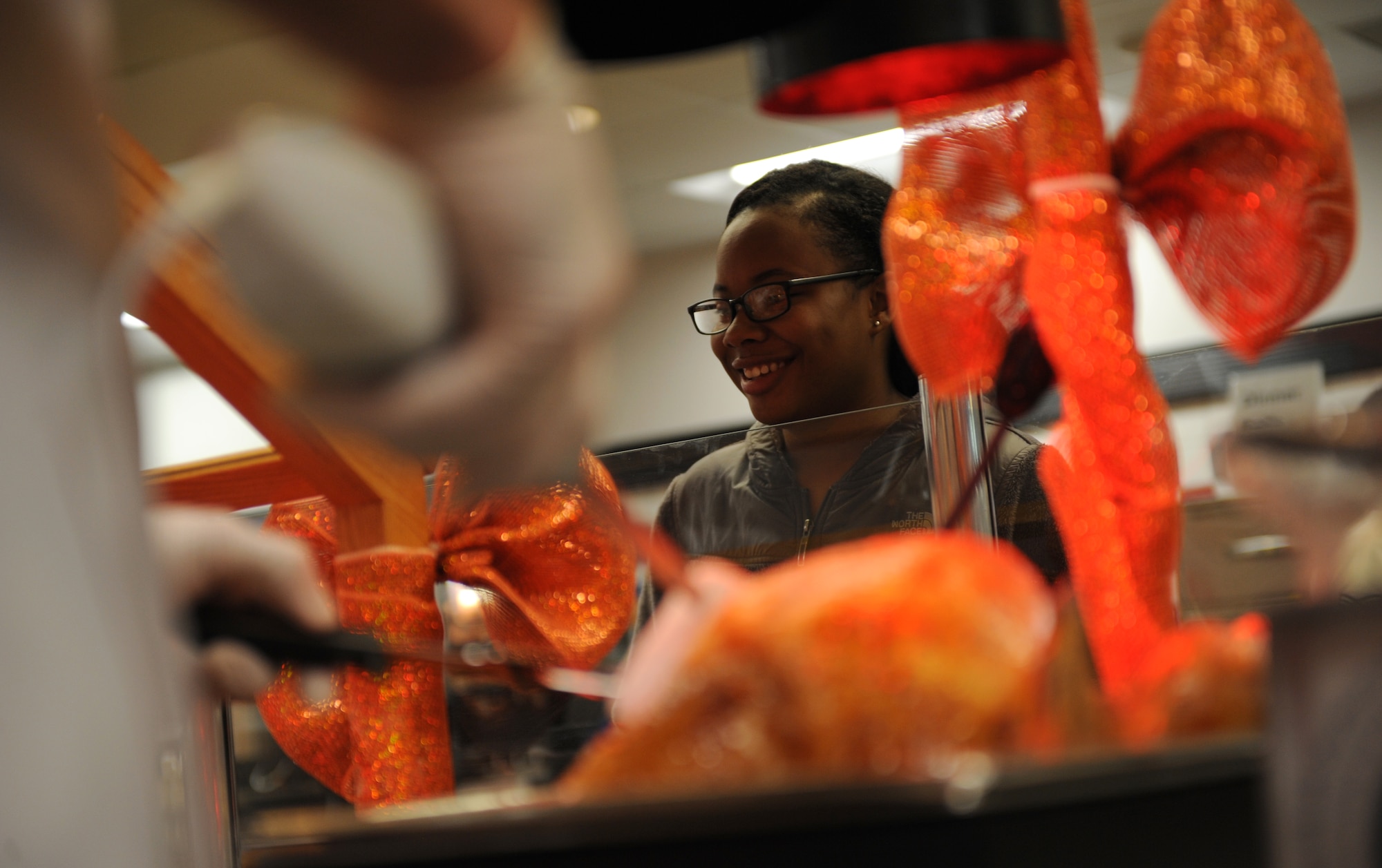 A member of Team Whiteman waits to receive a Thanksgiving meal at the Ozark Inn Dining facility on Whiteman Air Force Base, Mo., Nov. 28, 2014. Every year it is tradition that Whiteman’s senior leaders serve Airmen and their families as well as retirees. (U.S. Air Force photo by Airman 1st Class Joel Pfiester/Released)
