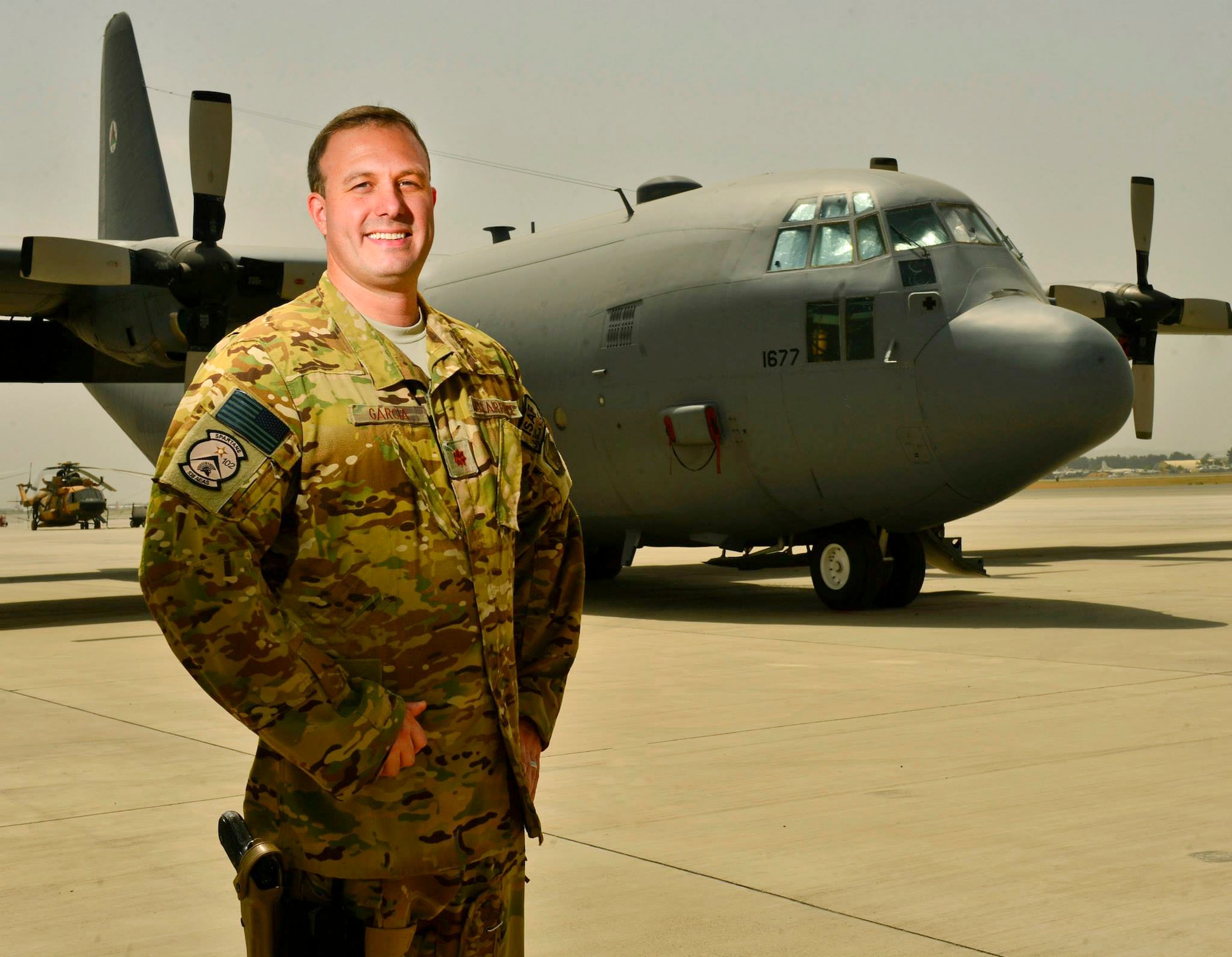 Lt. Col. Christopher Garcia, 538th Air Expeditionary Advisory Squadron director of operations, stands in front of an Afghan Air Force C-130 Hercules at Kabul International Airport, Afghanistan. Garcia assisted in training the first Afghan C-130 crew while assigned to the 538th Air Expeditionary Wing. (Courtesy photo)