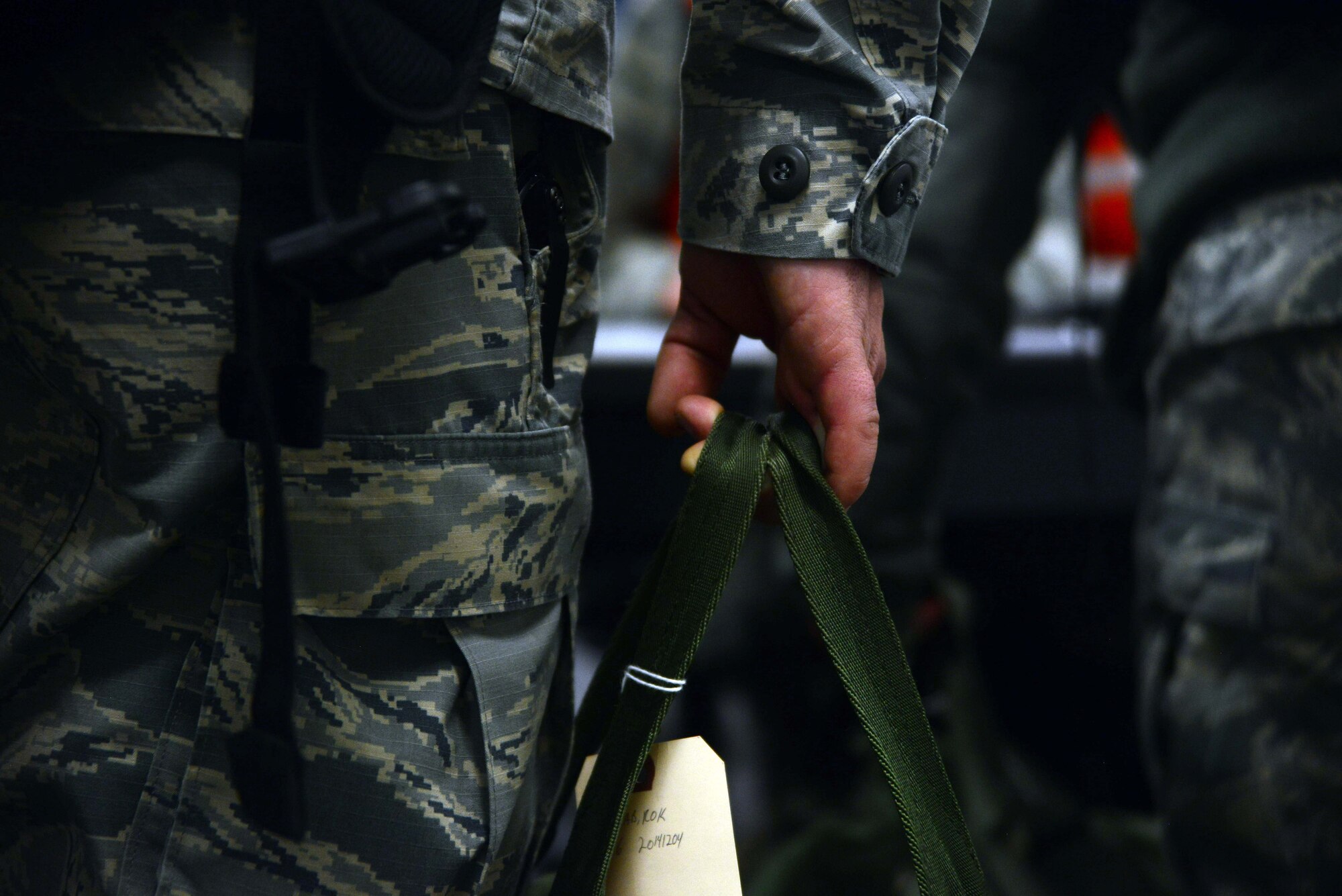 An Airman from the 35th Fighter Wing stands in a Personnel Deployment Function line holding his gear Dec. 4, 2014, at Misawa Air Base, Japan. Approximately 200 Airmen deployed as part of an exercise called Beverly Sunrise 15-1, and were required to pass through the PDF line before boarding a C-130 Hercules. (U.S. Air Force photo by Staff Sgt. Derek VanHorn/Released) 