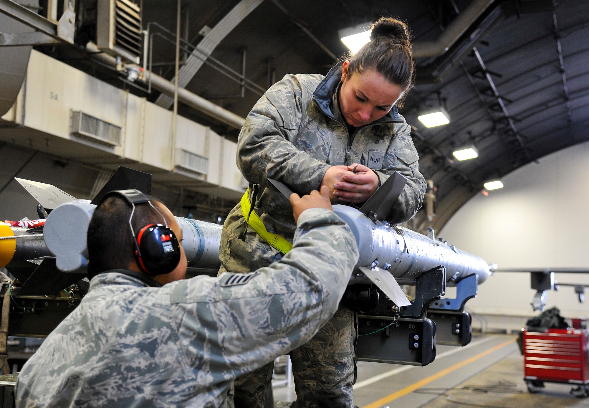 U.S. Air Force Senior Airman Kaitlyn McKenzie, 35th Maintenance Group weapons load crew member, and Staff Sgt. Eric Fontanilla, 13th Aircraft Maintenance Unit weapons load crew chief, tighten a stabilizer fin on an AIM-120 missile at Misawa Air Base, Japan, Dec. 4, 2014. During exercise Beverly Sunrise 15-1, McKenzie and fellow load crew members ensured munitions were properly affixed to all aircraft. Several F-16s and over 200 Airmen will deploy in support of this newly redesigned exercise in the Pacific region. (U.S. Air Force photo by Airman 1st Class Patrick S. Ciccarone/Released)