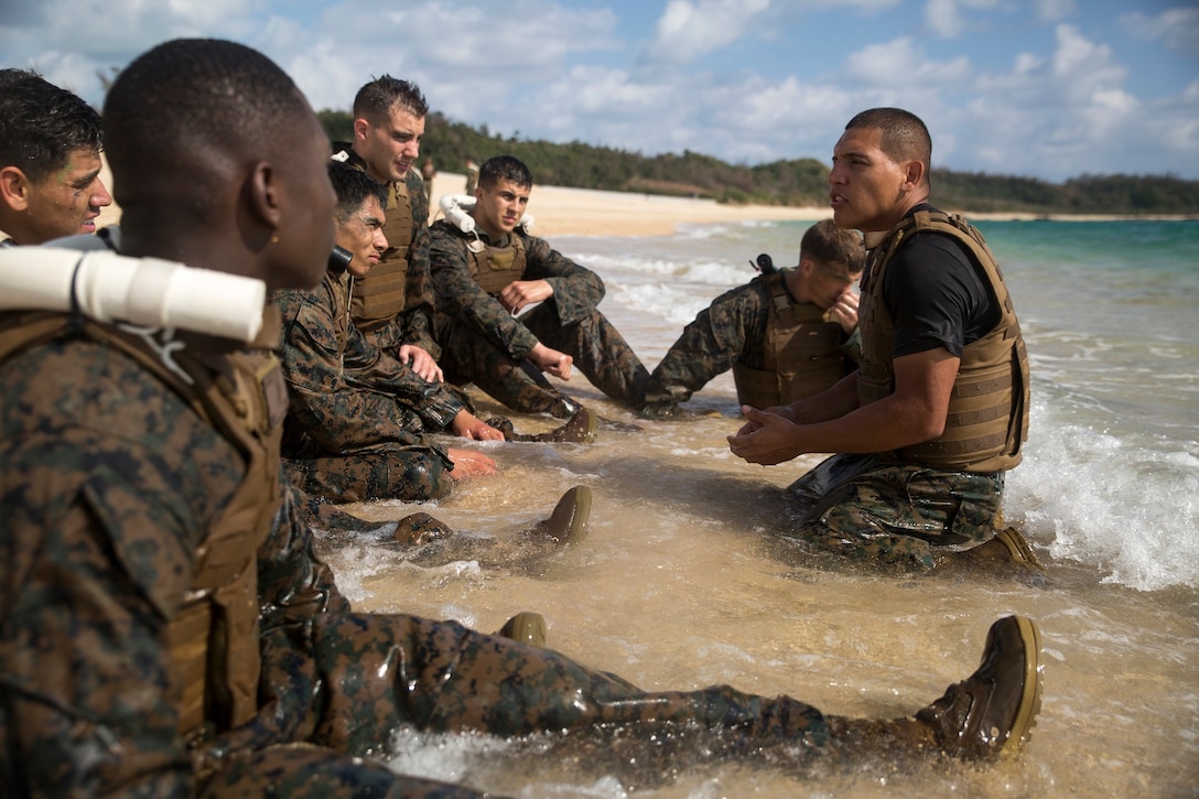 Staff Sgt. Rafael Garcialopez, right, passes Marine Corps Martial Arts Program fundamentals and knowledge to his squad Nov. 21, Kin Blue, Okinawa, during the culminating event for Marine Corps Martial Arts Instructor course class 1-15. MCMAP focuses on real life hand-to-hand combat survival techniques that also include leadership tie inns that help build confidence and leadership in the Marines. The culminating event pushed the Marines and sailor to their limits mentally and physically while challenging them with MCMAP fundamentals. The Marines and sailor in the course trained for three weeks in order to earn their instructor tab. After earning their tab, they now have the ability to practice and teach the disciplines and lessons they learned from the course. The course was run by Headquarters and Support Battalion, Marine Corps Installation Pacific-Marine Corps Base Camp Butler, Japan. Garcialopez is martial arts instructor-trainer and chief instructor for the course. 