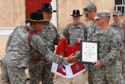 Command Sgt. Maj. John Cartwright Sr., squadron command sergeant major of 3rd Squadron, 278th Armored Cavalry Regiment of the Tennessee National Guard, shakes hands with 1st Sgt. Brian Belue, interim command sergeant major of the 1st Squadron, 98th Cavalry Regiment of the Mississippi National Guard, after a flag presentation during a transfer of authority ceremony at Contingency Operating Base Speicher, Iraq, March 10, 2010. The flag was presented to the 1/98 Cavalry from the 3/278 Cavalry as a gesture of southern hospitality.