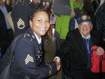 Sgt. Tammie K. Carr of the Operational Support Airlift Agency (OSAA), based at Fort Belvoir, Va., proudly shakes the hand of a very happy World War II veteran. On March 11,2010, about 250 veterans visited the National World War II Memorial and were honored by producers Tom Hanks and Stephen Spielberg in advance of their new HBO series, "The Pacific."