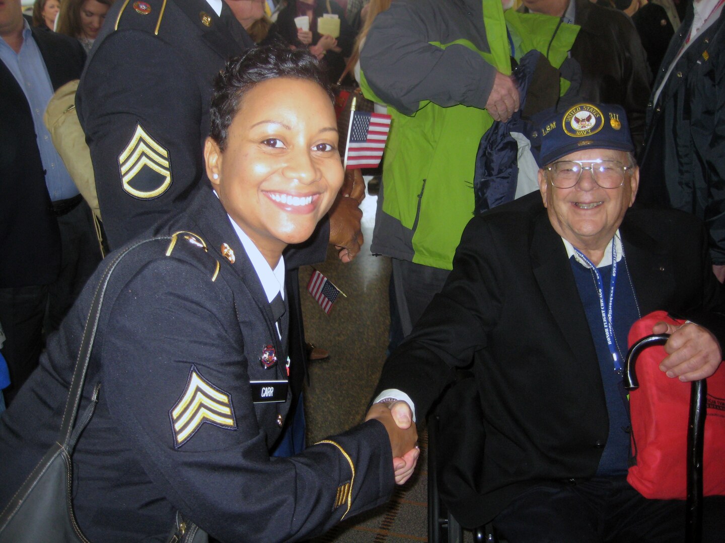 Sgt. Tammie K. Carr of the Operational Support Airlift Agency (OSAA), based at Fort Belvoir, Va., proudly shakes the hand of a very happy World War II veteran. On March 11,2010, about 250 veterans visited the National World War II Memorial and were honored by producers Tom Hanks and Stephen Spielberg in advance of their new HBO series, "The Pacific."