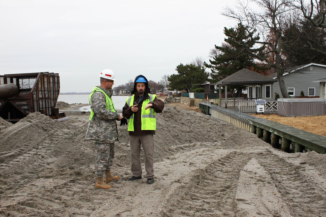 USACE Philadelphia District Commander Lt. Col. Michael Bliss discusses beachfill operations with Operations Chief Tony DePasquale at Oakwood Beach, N.J. in December of 2014. USACE and Great Lakes are pumping sand and building a berm system to reduce storm damages to the community. Work was funded by the Hurricane Sandy Relief Bill (PL 113-2). 