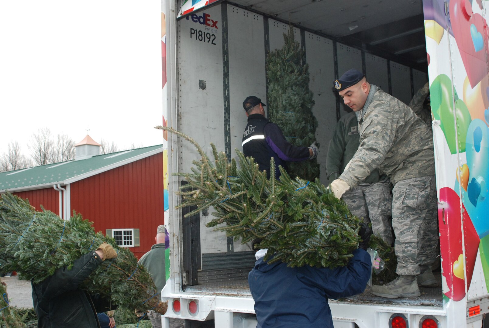 New York Air National Guard members of the 109th Airlift Wing from Scotia, N.Y. volunteer their time to assist FedEx driver Don Pelletier load Christmas Trees here at Ellms Christmas Tree Farm Dec. 7. Nearly 20 Airmen volunteered to assist in the annual "Trees for Troops" loading of about 150 donated trees bound for military installations and families around the country and the globe.