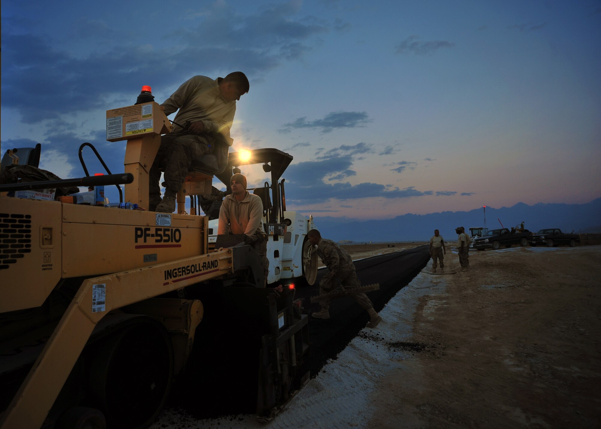 U.S. Air Force Airmen assigned to the 557th Expeditionary Rapid Engineer Deployable Heavy Operational Repair Squadron Engineers (RED HORSE) Squadron lay asphalt Dec. 2, 2014 at Bagram Airfield, Afghanistan. Completion of the road allowed for the safe transfer of munitions without inhibiting other base operations. (U.S. Air Force photo by Staff Sgt. Whitney Amstutz/released)