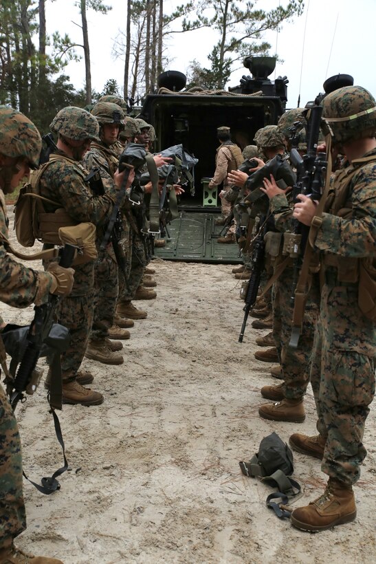 Marines with 3rd Platoon, Company A, Ground Combat Element Integrated Task Force, prepare to don life vests before boarding amphibious assault vehicles at Marine Corps Base Camp Lejeune, North Carolina, Dec. 2, 2014. Marines with AAV Platoon, Company B, GCEITF, transported Co. A Marines to the Verona Loop training area on Camp Lejeune to conduct a three-day live fire event with the M27 Infantry Automatic Rifle. (U.S. Marine Corps photo by Sgt. Alicia R. Leaders/Released)