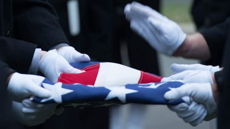The Navy Honor Guard folds Capt. Eli Takesian's service flag at his burial site in Arlington National Cemetery, Arlington, Va. on Dec. 4, 2014. Takesian died May 20, 2014 at the Walter Reed National Military Medical Center in Bethesda, Md. Takesian is most renowned for the care and aid he provided to the Marines of 1st Battalion, 5th Marine Regiment at the bloody battle of Hue City during the Vietnam War.