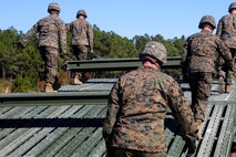 Marines with 8th Engineer Support Battalion, 2nd Marine Logistics Group, install the deck portion of a 12-bay, double-story, medium-girder bridge at Landing Zone Dove on Marine Corps Base Camp Lejeune, N.C., Nov. 19, 2014.  Marines finished the construction in less than six hours.  The training reinforced Marines skills in building a bridge that can support the weight of a tank. (Marine Corps photo by Lance Cpl. Kirstin Merrimarahajara/released)