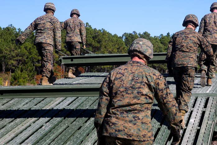 Marines with 8th Engineer Support Battalion, 2nd Marine Logistics Group, install the deck portion of a 12-bay, double-story, medium-girder bridge at Landing Zone Dove on Marine Corps Base Camp Lejeune, N.C., Nov. 19, 2014.  Marines finished the construction in less than six hours.  The training reinforced Marines skills in building a bridge that can support the weight of a tank. (Marine Corps photo by Lance Cpl. Kirstin Merrimarahajara/released)