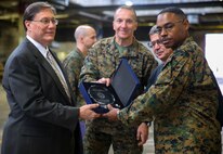 Mr. Paul Peters, acting Assistant Secretary of Defense for Logistics and Materiel Readiness, presents the Department of Defense 2013 Packing Achievement Award to 2nd Supply Battalion, Combat Logistics Regiment 25, 2nd Marine Logistics Group, during a ceremony aboard Camp Lejeune, N.C., Dec. 3, 2014. The Marines maintained a remarkable safety record, completing over 8,000 hours of incident-free work.