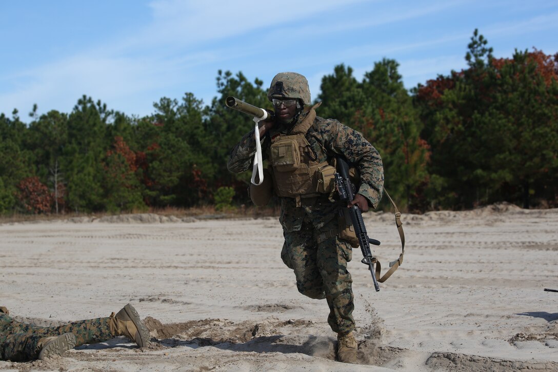 Lance Cpl. Amadu Kanu, combat engineer with Engineer Platoon, Headquarters and Service Company, Ground Combat Element Integrated Task Force, advances to an objective with an M1A2 Bangalore torpedo during an assault breaching exercise at Engineer Training Area 2 at Marine Corps Base Camp Lejeune, North Carolina,  Dec. 3, 2014. (U.S. Marine Corps photo by Cpl. Paul S. Martinez/Released)