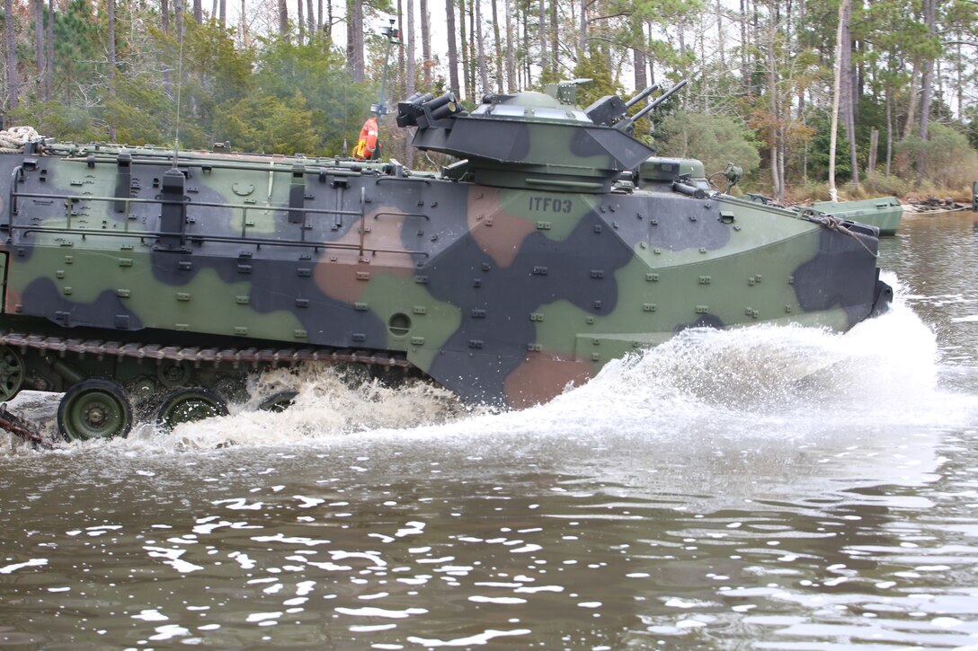 Marines with the Amphibious Assault Vehicle Platoon, Company B, Ground Combat Element Integrated Task Force, splash into the New River from the French Creek loading dock at Marine Corps Base Camp Lejeune, North Carolina, Dec. 2, 2014. Marines with AAV Platoon, Company B, GCEITF, transported Co. A Marines to the Verona Loop training area on Camp Lejeune to conduct a three-day live-fire training event with the M27 Infantry Automatic Rifle. (U.S. Marine Corps photo by Sgt. Alicia R. Leaders/Released)