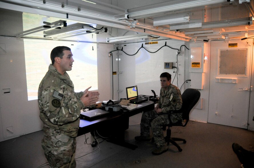 Tech. Sgt. Robert Ellis, Detachment 1 Joint Terminal Attack Controller liaison and evaluator, briefs Lt. Gen Stanley E. Clarke III, director of the Air National Guard, and representatives from the 188th Wing and United States Navy on close-air support training capabilities afforded by Razorback Range’s proximity to the 188th Wing Dec. 5, 2014. The range is maintained by the 188th and provides varying types of training to military units from around the world that includes close-air support training with joint terminal attack controllers. (U.S. Air National Guard photo by Airman 1st Class Cody Martin/released)