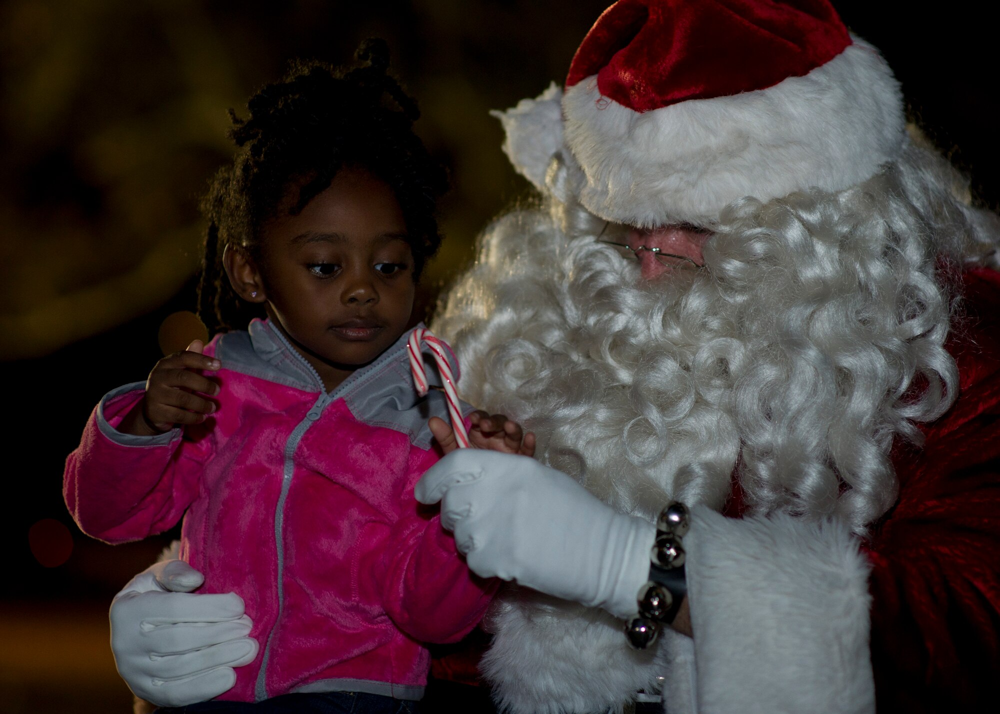 Santa Claus gives a candy cane to Madison Moore at the annual tree lighting ceremony Dec. 4 at Flag Park. The ceremony offered free cookies and chocolate milk, as well as, gave children the opportunity to meet with Santa and discuss what they wanted for Christmas. (U.S. Air Force photo by Airman 1st Class Dustin Mullen)