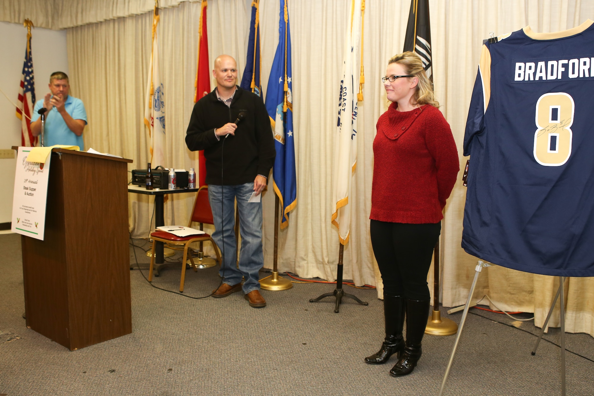 Staff Sgt. Ashley Osborn, right, a flight medic with the 137th Aeromedical Evacuation Squadron, receives a standing ovation on November 1 after sharing her story at the 16th annual Operation Holiday Spirit fundraiser at the Del City American Legion. Osborn received support from the organization three years ago when her son was hospitalized and diagnosed with meningitis. (U.S. Air Force photo/Staff Sgt. Caleb Wanzer)