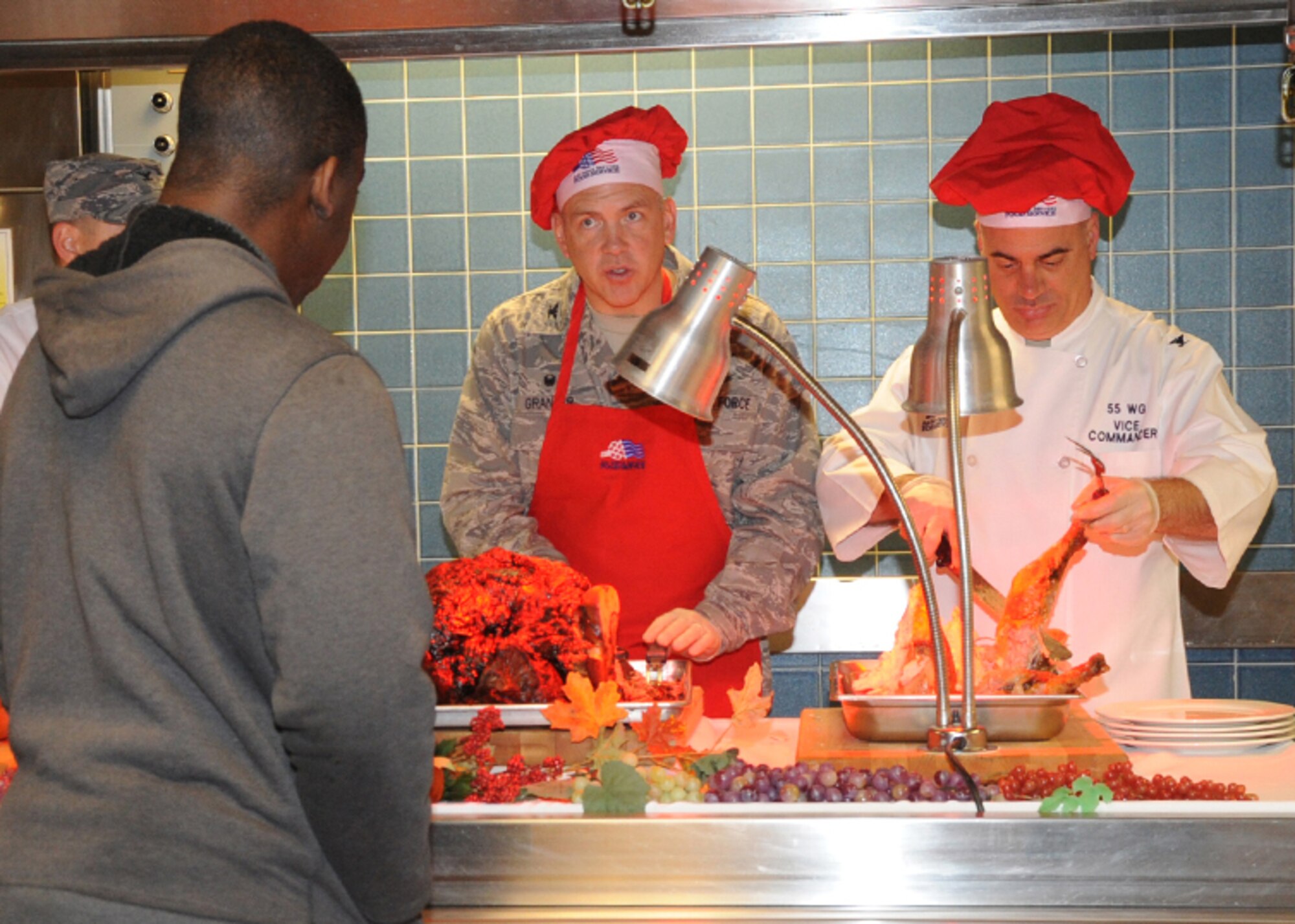 (Left to Right) U.S. Air Force Col. Jeffrey Granger, 55th Communications Group commander and U.S. Air Force Col. Mark Williamson, 55th Wing vice commander serve Thanksgiving meals to service members as they make their way through the line at the Ronald L. King Dining Facility on Offutt Air Force Base, Neb. Nov. 27. Leadership from Team Offutt including U.S. Navy Adm. Cecil D. Haney, U.S. Strategic Command commander and U.S. Air Force Brig. Gen Gregory Guillot, 55th Wing commander were also serving food to service members, veterans and families to show their appreciation for all they do. (U.S. Air Force photo by Kendra Williams/Released)