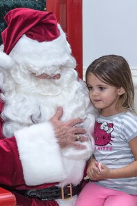 Emmie Cramer has her photo taken with Santa during the annual Christmas tree lighting ceremony Dec. 4 at Joint Base San Antonio-Randolph’s Washington Circle. Santa posed for photos with children inside JBSA-Randolph’s Taj rotunda. (U.S. Air Force photo by Johnny Saldivar)