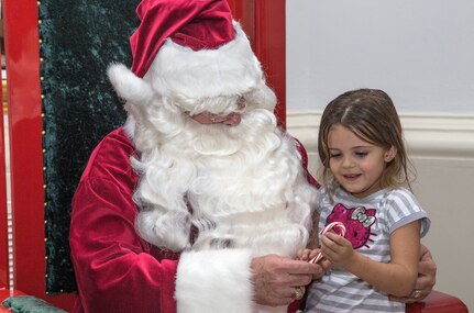 Emmie Cramer has her photo taken with Santa during the annual Christmas tree lighting ceremony Dec. 4 at Joint Base San Antonio-Randolph’s Washington Circle. Santa posed for photos with children inside JBSA-Randolph’s Taj rotunda. (U.S. Air Force photo by Johnny Saldivar)