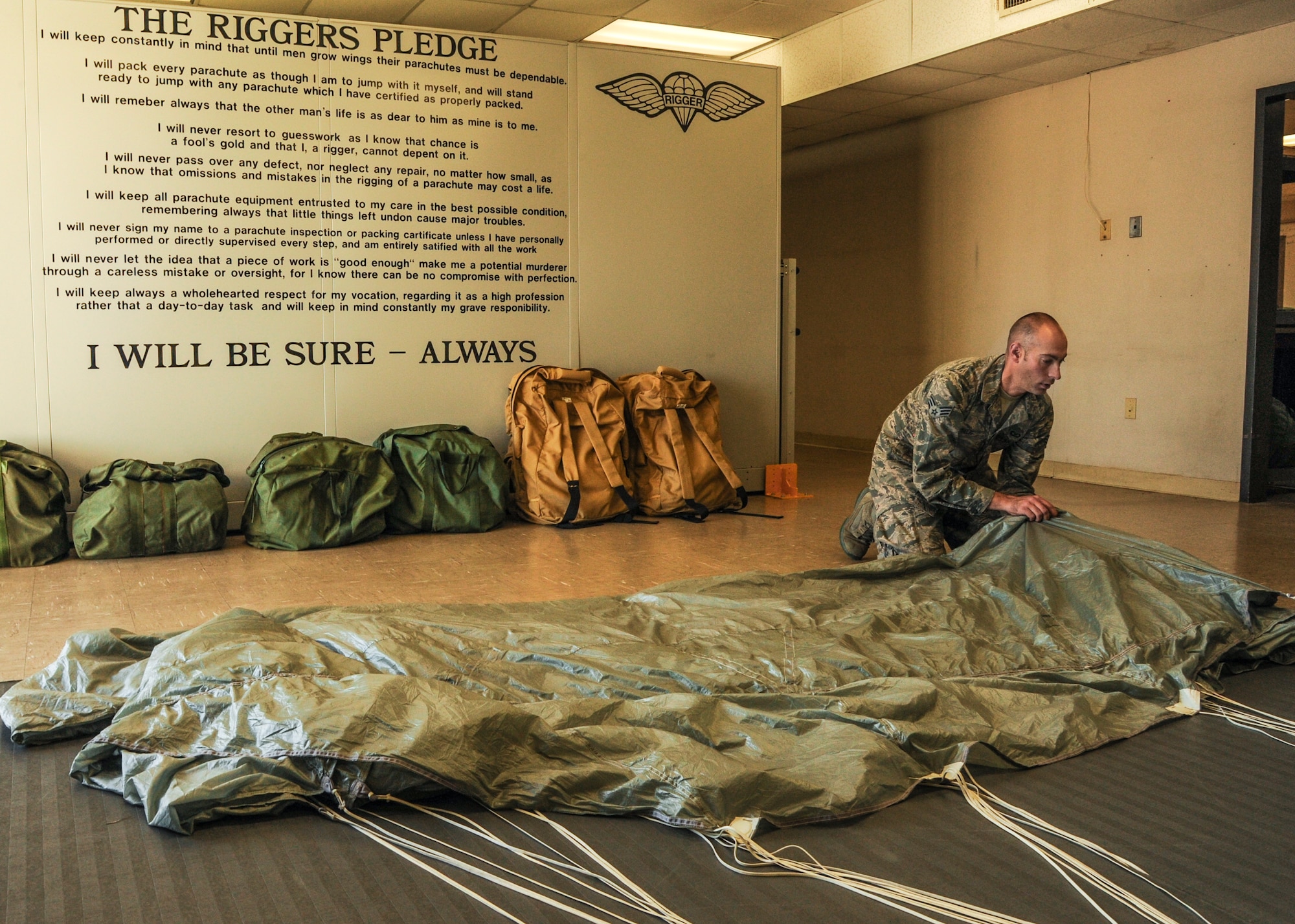 Senior Airman Adam Selig, a 19th Operations Support Squadron aircrew flight equipment journeyman, folds a parachute Nov. 25, 2014, at Little Rock Air Force Base, Ark. Selig prepares parachutes to be placed in C-130s. (U.S. Air Force photo by Airman 1st Class Mercedes Muro)