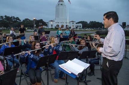Hector Perez, Randolph Field High School Band director, conducts students through a variety of holiday songs during the annual tree lighting ceremony Dec. 4 at JBSA-Randolph’s Washington Circle . The Joint Base San Antonio-Randolph community gathered for the tree lighting event to kick off the holiday season. (U.S. Air Force photo by Johnny Saldivar)