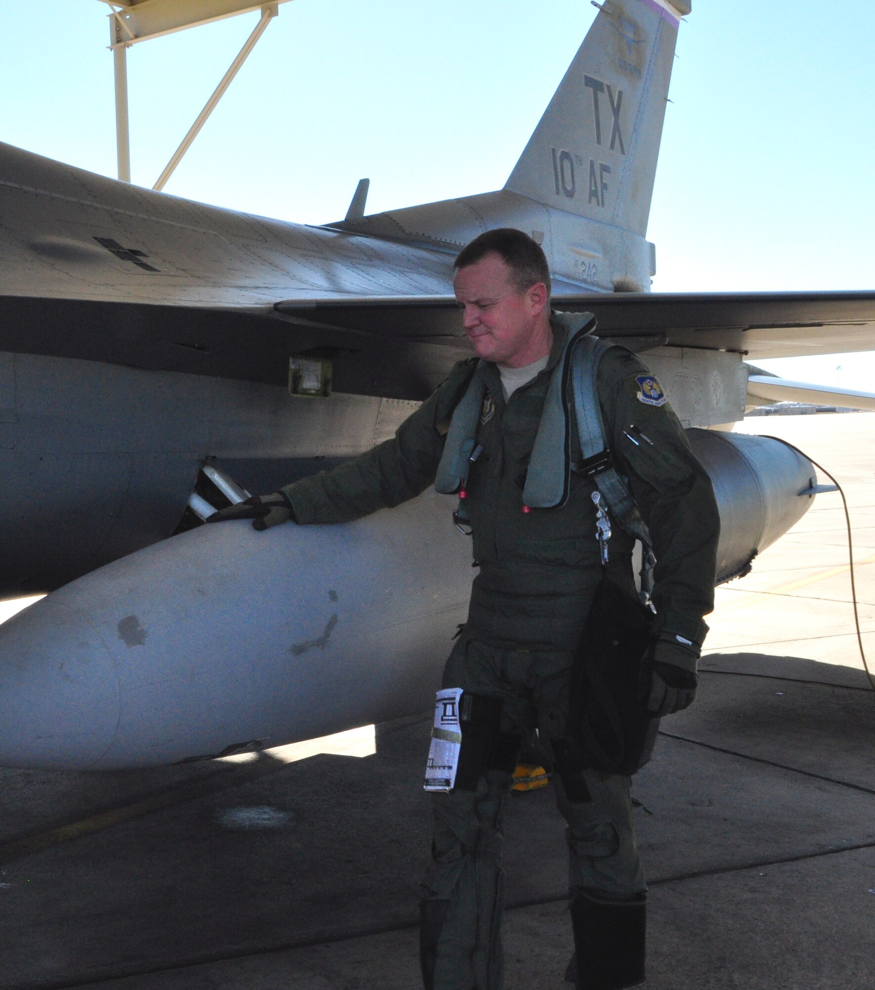 Col. Bruce Cox, 10th Air Force A3/A7 director of Operations and Plans, gives his F-16 one final check before he flies his 'fini' flight in the Fighting Falcon at Naval Air Station Fort Worth Joint Reserve Base, Texas. Col. Cox is leaving to become the 307th Bomb Wing commander at Barksdale Air Force Base, La. (U.S. Air Force photo/Master Sgt. Julie Briden-Garcia)