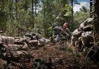 An Army Ranger student cleans his weapon prior during some down time in the woods of the Eglin Air Force Base, Fla., range. Students complete the final phase of the Army Ranger course with the 6th Ranger Training Battalion. Instructors expose the students to 18-day field training that includes airborne and helicopter assaults, small boat operations, river and swamp crossings. (U.S. Air Force photo/Tech. Sgt. Samuel King Jr.)