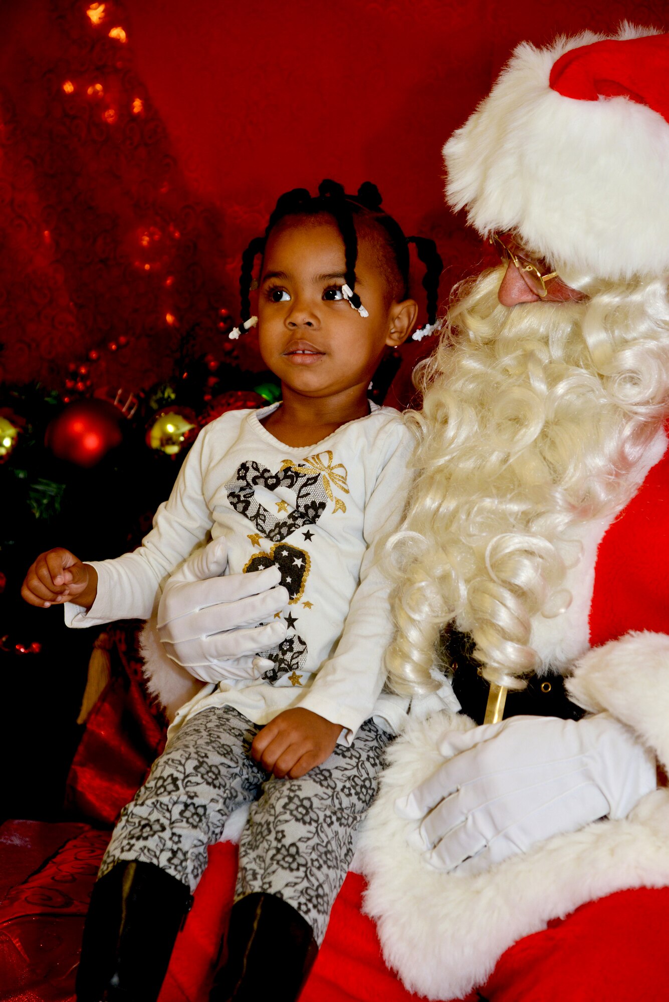 Ada Brandon visits with Santa Claus at the Tree Lighting Ceremony at the Base Chapel Dec. 4. All planned festivities were moved inside the chapel due to rainy weather. (Photo by Jamie Burnett)