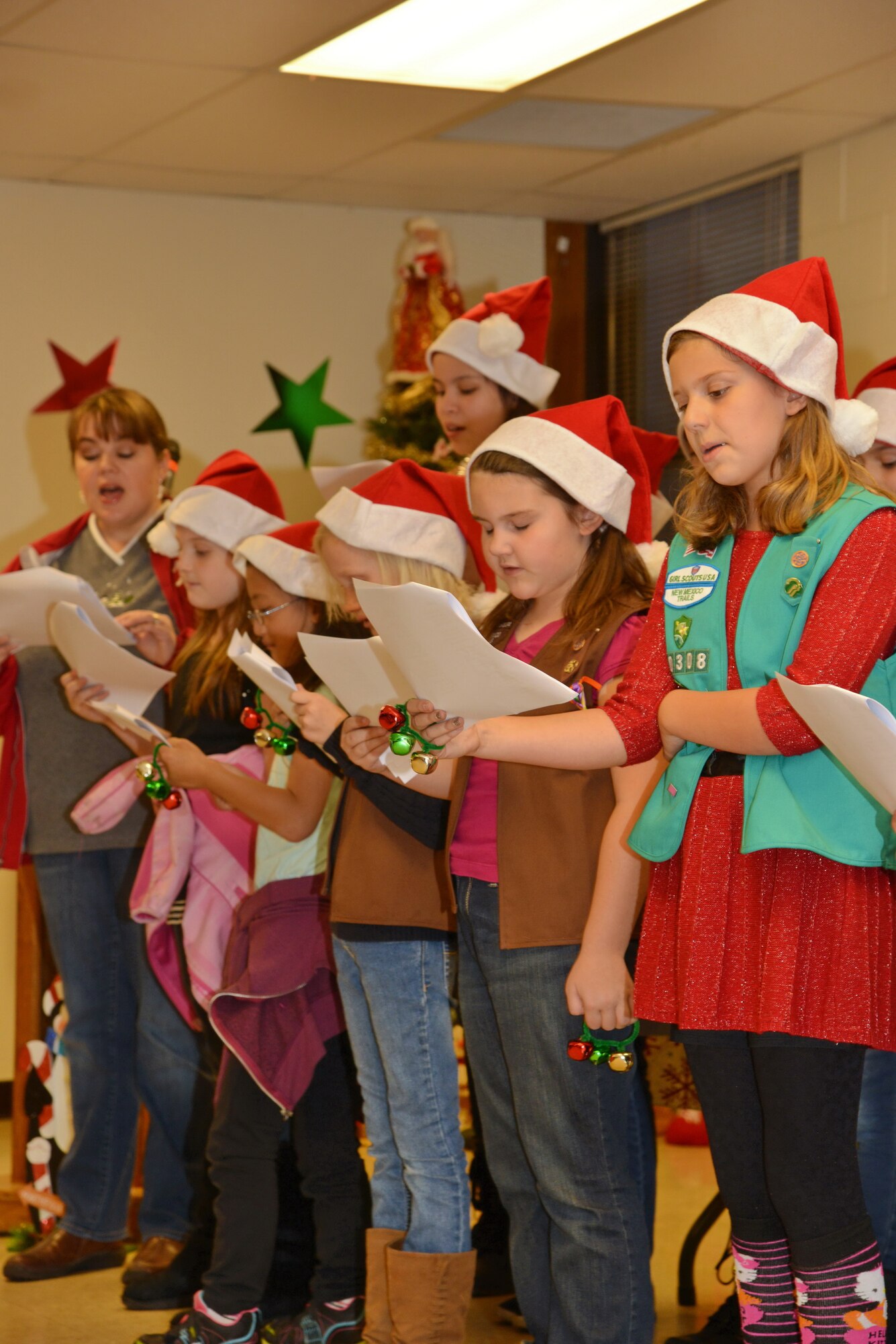 Girl Scout Troop 10308 sings holiday carols at the Tree Lighting Ceremony at the Base Chapel Dec. 4. All planned festivities were moved inside the chapel due to rainy weather. (Photo by Jamie Burnett)