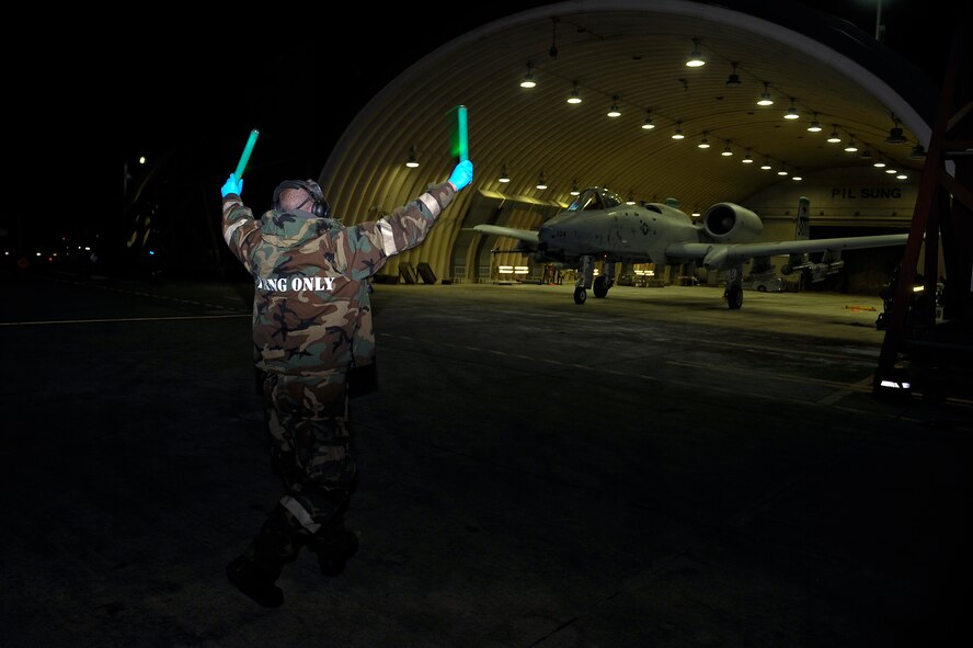Staff Sgt. Robert Dupree, 25th Aircraft Maintenance Unit dedicated crew chief, marshals an A10 Thunderbolt II pilot Dec. 5, 2014, during Exercise Beverly Bulldog 15-01 at Osan Air Base, Republic of Korea. The exercise focuses on readiness, testing Osan’s wartime procedures, and realistically looking at our ability to defend the base, execute operations and receive follow-on forces. (U.S. Air Force photo by Senior Airman David Owsianka)
