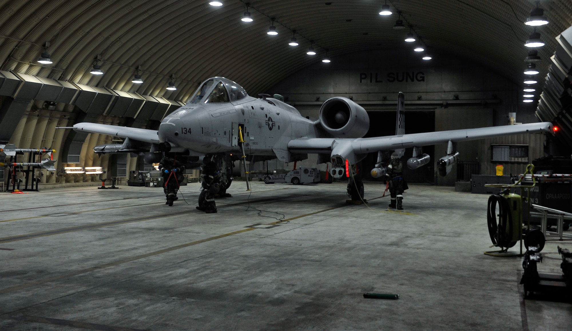 Airmen remove aircraft chocks from an A10 Thunderbolt II Dec. 5, 2014, during Exercise Beverly Bulldog 15-01 at Osan Air Base, Republic of Korea. The exercise focuses on readiness, testing Osan’s wartime procedures, and realistically looking at our ability to defend the base, execute operations and receive follow-on forces. (U.S. Air Force photo by Senior Airman David Owsianka)