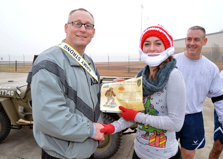 Col. Michael Harvey, Operation Toy Drop ground operations officer in charge assigned to U.S. Army Civil Affairs and Psychological Operations Command (Airborne), left, congratulates 1st Lt. Lorin Hoover, 43rd Aeromedical Evacuation Squadron, for finishing first place for the females during Pope Field’s annual Operation Toy Trot 5K race around the Pope Field flight line on Dec. 3. Over 150 Fort Bragg Airmen and Soldiers dressed in holiday and fitness attire, donated toys and participated in the race to help kickoff this year’s Operation Toy Drop from Dec. 5 thru Dec. 7. (U.S. Air Force photo/Marvin Krause)