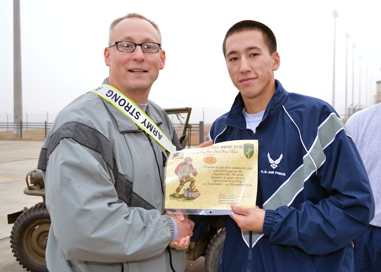 Col. Michael Harvey, Operation Toy Drop ground operations officer in charge assigned to U.S. Army Civil Affairs and Psychological Operations Command (Airborne), left, congratulates Airman 1st Class Benjamin Latimer, 43rd Logistics Readiness Squadron, for finishing first place for the males during Pope Field’s annual Operation Toy Trot 5K race around the Pope Field flight line on Dec. 3. Over 150 Fort Bragg Airmen and Soldiers dressed in holiday and fitness attire, donated toys and participated in the race to help kickoff this year’s Operation Toy Drop from Dec. 5 thru Dec. 7. (U.S. Air Force photo/Marvin Krause)