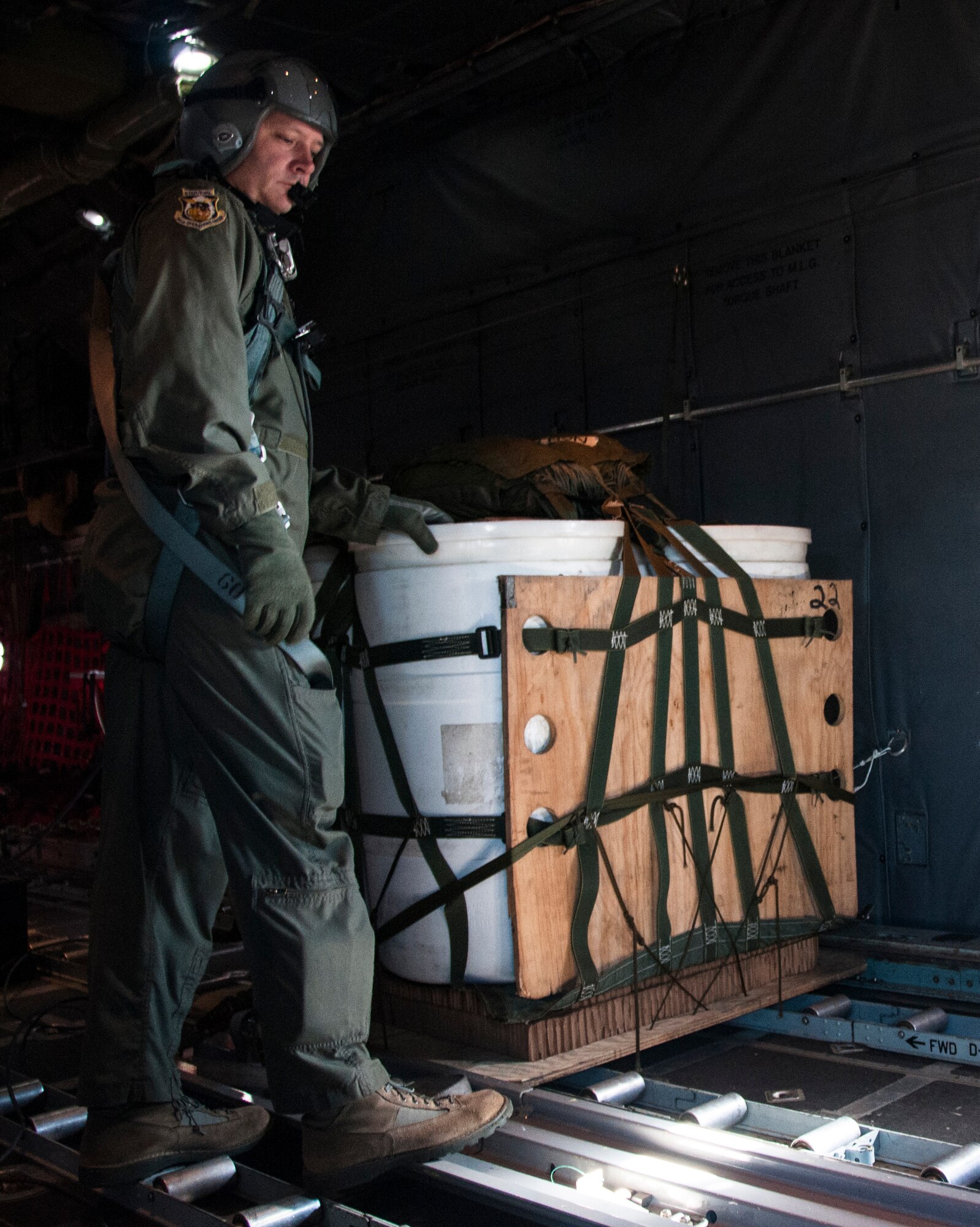 Senior Master Sgt. Bill Hutchinson, 700th Airlift Squadron loadmaster, waits for the “go” signal on an air drop mission aboard a U.S. Air Force C-130 Hercules Nov. 20, 2014. In an aerial delivery role, the Hercules can airdrop loads up to 42,000 pounds or use its high-flotation landing gear to land and deliver cargo on rough, dirt strips. (U.S. Air Force photo by Senior Airman Daniel Phelps/Released)