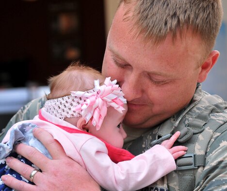 WRIGHT-PATTERSON AIR FORCE BASE, Oho - Family and friends greet Senior Airman Christopher Peterson, 87th Aerial Port Squadron, as he meets his 3-month-old daughter, Olivia, for the first time at the Dayton International Airport May 3 upon his return home from his deployment. Olivia was born while Peterson was deployed to the Transit Center, Manas, Kyrgyzstan. (U.S. Air Force photo/Tech. Sgt. Frank Oliver)
