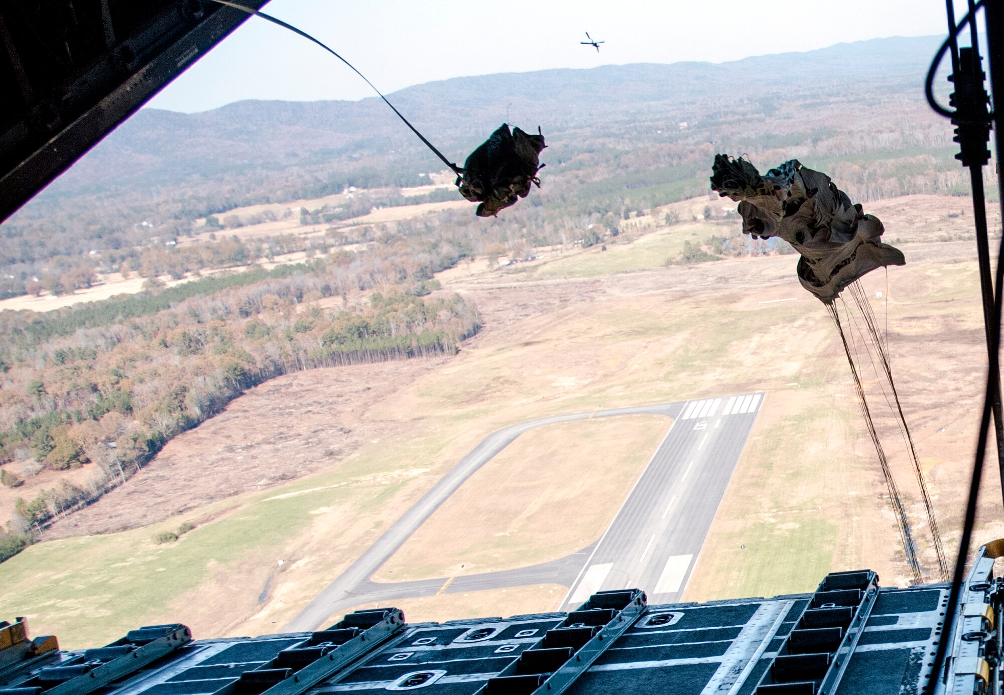 A parachute is released from cargo falling out of the back of a U.S. Air Force C-130 Hercules Nov. 20, 2014. Using its aft loading ramp and door, the C-130 can accommodate a wide variety of oversized cargo, including everything from utility helicopters and six-wheeled armored vehicles to standard palletized cargo and military personnel. (U.S. Air Force photo by Senior Airman Daniel Phelps/Released