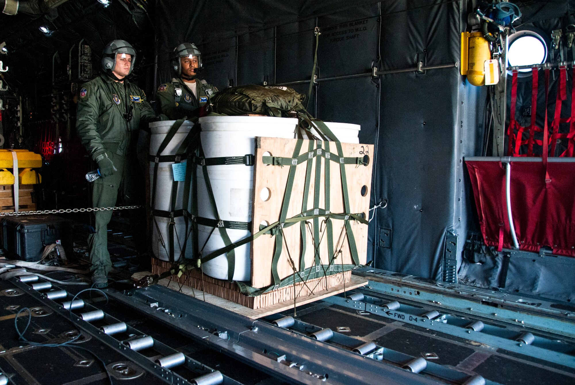 Tech. Sgt. Mark Hanson and Senior Airman Wes Brown, 700th Airlift Squadron loadmasters, inspect cargo for an air drop over Georgia Nov. 20, 2014. Loadmasters accomplish loading and off-loading aircraft functions; and perform pre-flight and post-flight of aircraft and aircraft systems. (U.S. Air Force photo by Senior Airman Daniel Phelps/Released)