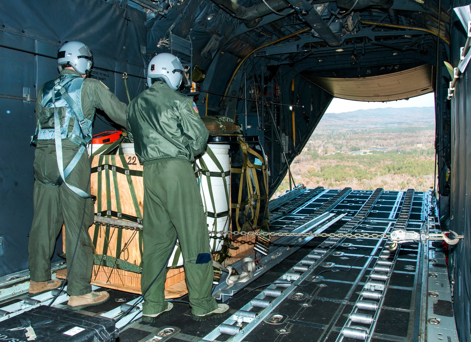 Loadmasters from the 700th Airlift Squadron await the signal to drop cargo during a training mission for the new wireless gate release equipment Nov. 20, 2014. The 700th Airlift Squadron maintains combat ready aircrews and aircraft capable of deploying in response to worldwide contingencies and emergencies. (U.S. Air Force photo by Senior Airman Daniel Phelps/Released)