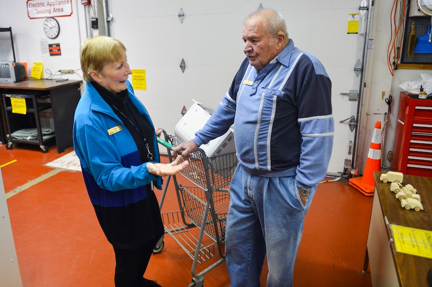Joan Wasserstrom, McChord Thrift Shop volunteer, delivers a toaster oven to Del Keefauver, McChord Thrift Shop volunteer, to price and put on the shelves for sale Dec. 5, 2014 at Joint Base Lewis-McChord, Wash.  Money raised by the McChord Thrift Shop is donated to local charities and organizations such as the 62nd and 446th First Sergeants Councils, Airmen and Family Readiness Center, Fisher House, Deployed Family Dinner’s and many more. (U.S. Air Force photo/Staff Sgt. Russ Jackson)