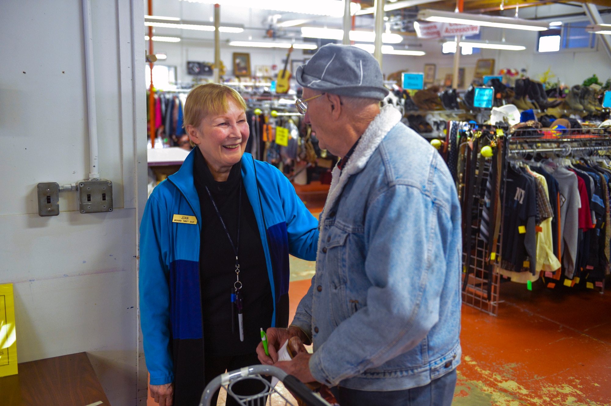 Joan Wasserstrom, McChord Thrift Shop volunteer, speaks with a customer Dec. 5, 2014 at Joint Base Lewis-McChord, Wash. For the last 38 years, Wasserstrom has had her hand in running the thrift shop which has been a success for Airmen, their families and organizations at McChord Field. (U.S. Air Force photo/Staff Sgt. Russ Jackson)