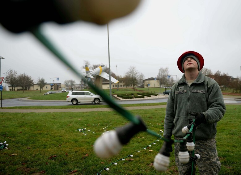 U.S. Air Force Senior Airman Zachery Evans, a 52nd Civil Engineer Squadron electrical systems journeyman and native of Clintwood, Va., decorates an evergreen tree at the Saber Circle on Spangdahlem Air Base, Germany, Dec. 2, 2014. The 52 CES ensured the tree’s placement and decoration as per holiday tradition. (U.S Air Force photo by Airman 1st Class Timothy Kim/Released)