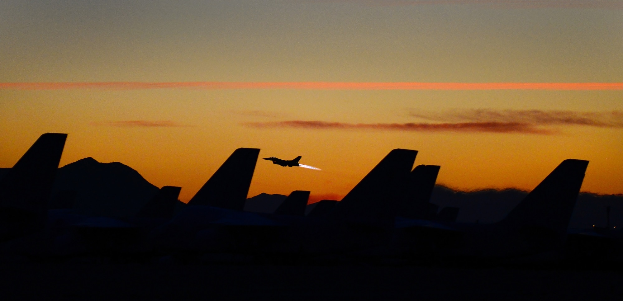 DAVIS-MONTHAN AIR FORCE BASE, Arizona - A fighter jet launches at sunset at Davis-Monthan AFB, AZ in March of 2014. The pilot was headed out for a training mission and passed over the 309th Aerospace Maintenance and Regeneration Group, also known as the Boneyard. (U.S. Air Force photo/Tech. Sgt. Frank Oliver)