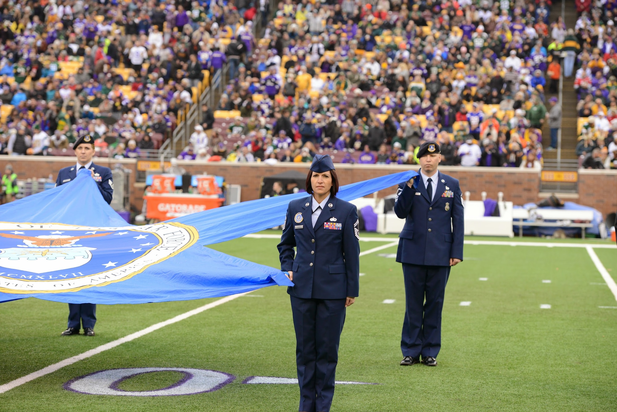 Senior Master Sgt. Christa Collier, 934th AW senior recruiter, and Master Sgt. Chris Blackledge, 934th Security Forces Squadron, unfurl the Air Force shield star at the Vikings vs. Packers game here Nov. 23. The ceremony was part of Viking's Military appreciation Day. (MN National Guard photo)